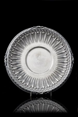 Centrotavola in argento con bordo cesellato a palmette e sbalzato a bugnature,