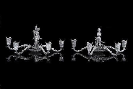 Coppia di candelieri a quattro fiamme in argento con braccia cesellate a volute