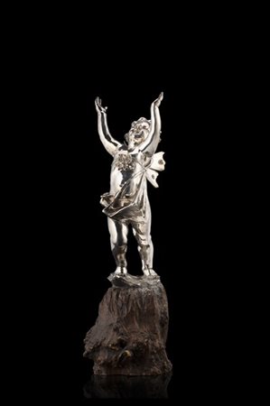 Putto alato in metallo argentato (h. cm 33) poggiante su base lignea. 1920 circ