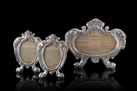 Gruppo di tre cartagloria in argento inciso e cesellato a teste di cherubini, v