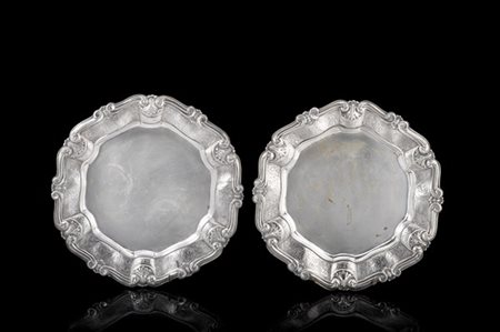 Coppia di vassoi in argento sbalzato con bordo polilobato cesellato a volute. T