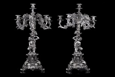 Coppia di candelabri in peltro argentato a otto fiamme, bracci a doppia voluta