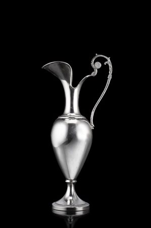 Versatoio in argento a corpo liscio e cesellato a palmette, ansa mossa incisa a