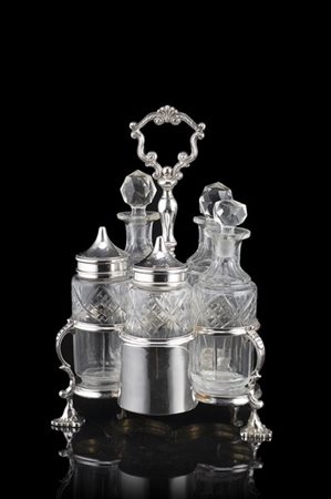 Porta cruet in argento di forma mossa con presa ad anello cesellato a volute, p