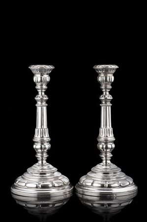 Coppia di candelieri in argento con fusto a colonna scanalata, base circolare.