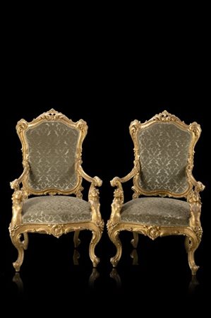 Coppia di poltrone in legno scolpito e dorato, braccioli retti da polene. Secol