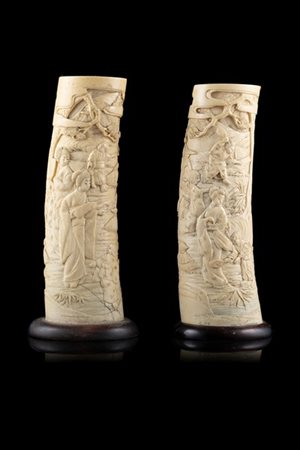 Coppia di zanne finemente intagliate con figure in paesaggio, basi in legno
Gia