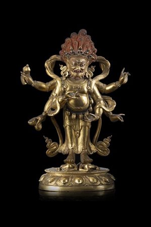 Scultura in bronzo dorato raffigurante Mahakala stante su due figure con testa