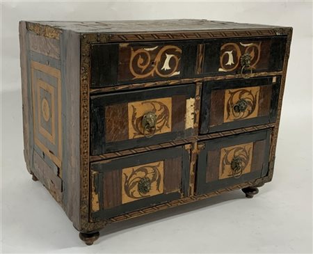 Stipo lastronato e intarsiato in legni vari. Fronte a un cassetto grande e quat