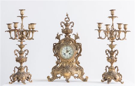 Trittico in bronzo, composto da coppia di candelabri e orologio. Di gusto...