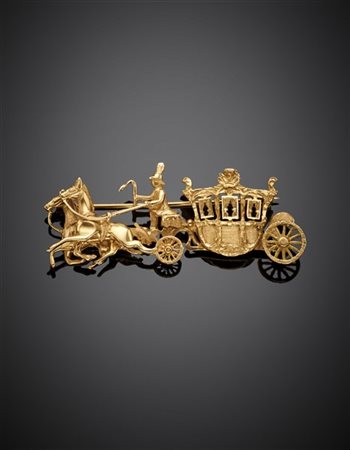 Spilla a guisa di cocchio in oro giallo, g 14,22 circa, largh. cm 6,10 circa.