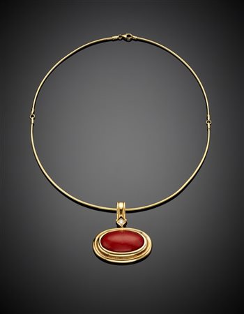 Collier articolato in oro giallo a tenere un pendente con corallo ovale cabocho