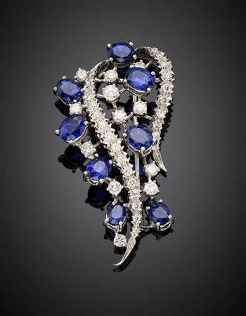 Spilla a volute in oro bianco con zaffiri e diamanti, g 8,53 circa, lungh. cm 4