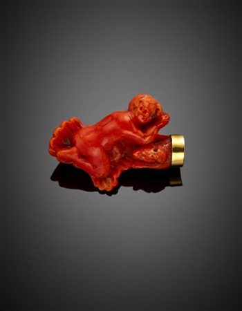 Spilla in oro giallo e corallo arancione scolpito a guisa di putto, dettagli in