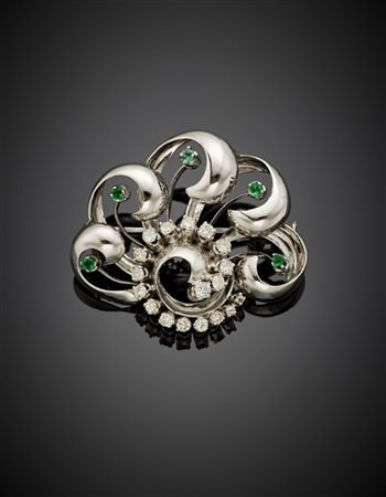Spilla a volute in oro bianco con diamanti e smeraldi, g 12,65 circa, largh. cm