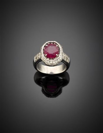 Anello in oro bianco con corindone rosso ovale centrale rifinito da diamanti pe