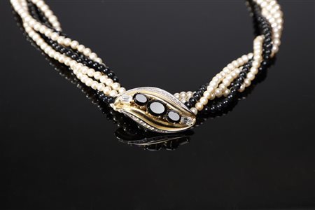 CARDIN PIERRE  - Collier torchon con fili di perle artificiali colorate bianche e nere. Fibbia a forma di foglia stilizzata con strass bianchi e neri.