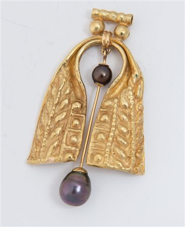 Pendente in oro e perle. In oro sbalzato e inciso, al centro elemento snodato decorato con due perle coltivate nere di acqua dolce. Peso complessivo: 23,4 grammi. Gioiello ad opera dell'..