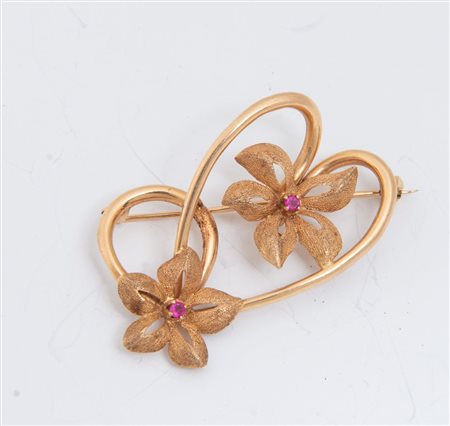 SPILLA IN ORO A doppio motivo floreale in oro giallo 18K, pistilli in rubini...
