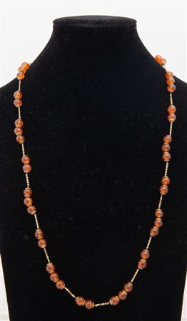 COLLANA IN ORO GIALLO E CORNIOLE. Realizzato come una lunga alternanza di...