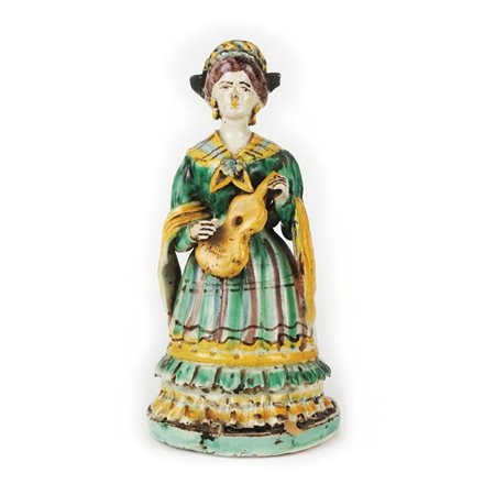 Lucerna in maiolica policroma raffigurante una donna in costume popolare che...
