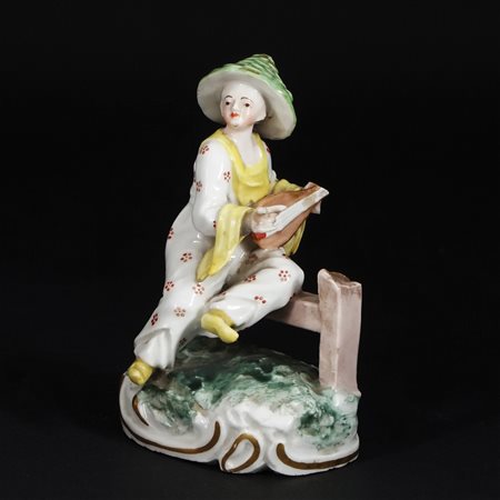 Scultura in porcellana policroma raffigurante un suonatore asiatico seduto....