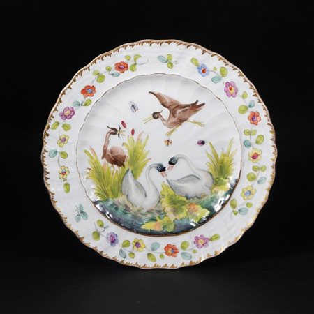 Piatto in porcellana bianca, policroma e dorata, dal "Servito dei Cigni"....
