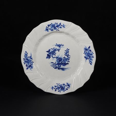 Piatto in terraglia bianca e blu: composizioni di fiori ornano sia il cavetto...