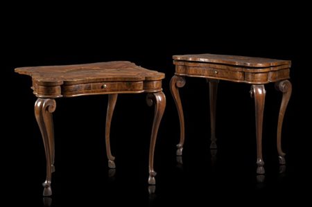 Coppia di tavoli da gioco di forma mossa lastronati in noce, filettati e intarsiati in legno chiaro e bois de rose