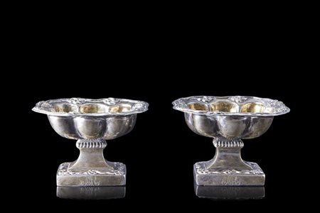 Coppia di saliere in argento sbalzato e baccellato con bordi decorati a motivo