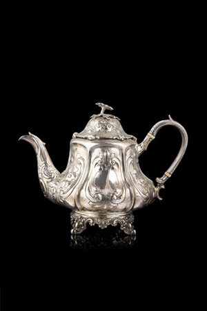 Teiera in argento a corpo piriforme sbalzato e inciso a volute e motivi floreal