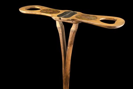 Bastone seggiolino in legno inciso con profilo di cane, decori vegetali e inizi