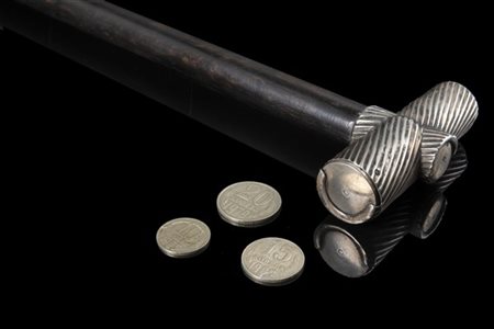 Bastone in ebano con presa portamonete a molle in argento scanalato. Puntale in