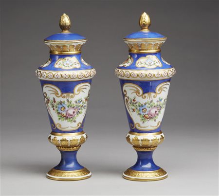  MANIFATTURA DI SEVRES DEL XIX SECOLO - Coppia di vasi con coperchi in porcellana parzialmente dorata e dipinta nei toni dell'azzurro e a decori floreali, poggianti su basi circolari.