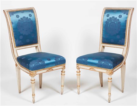 Set di quattro sedie in legno intagliato, laccato avorio e lumeggiato in oro....