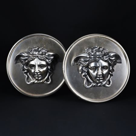 Coppia di placche circolari in ottone con finitura al nichel raffiguranti il...