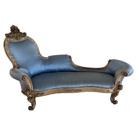 Dormeuse in legno dorato, di linea sinuosa. L'intera struttura è percorsa da...