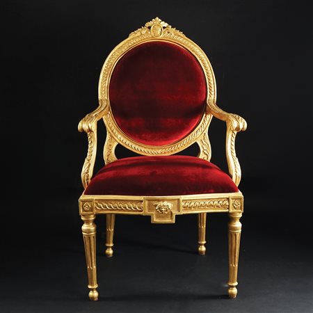 Poltrona in legno dorato interamente scolpito a dischetti ricorrenti;...