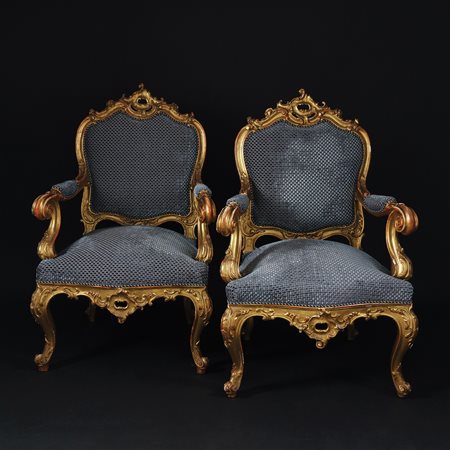 Coppia di poltrone in legno dorato. Dossello di linea mossa riccamente...