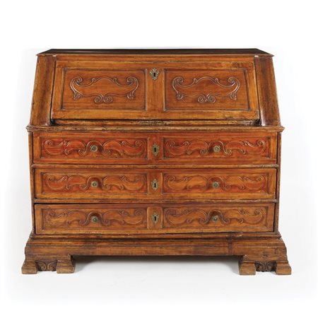 Ribalta in noce. Fronte a tre cassetti intagliati a volute sottesi a una...