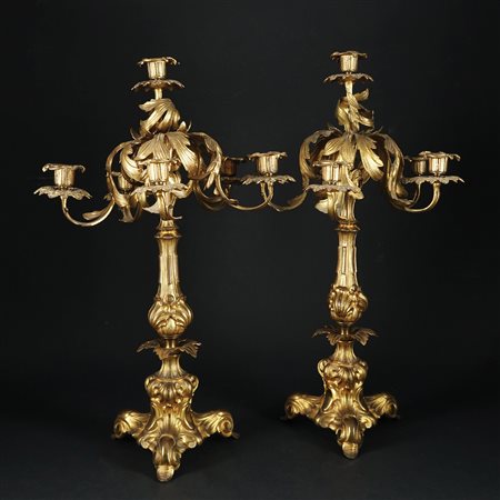 Coppia di candelabri in bronzo dorato a sei luci ciascuno. Stelo cesellato a...