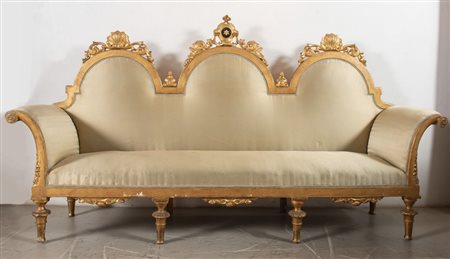DIVANO in legno intagliato e dorato. Schienale con tre mosse recante cimasa...