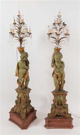 COPPIA DI PUTTI reggenti torciere in legno intagliato laccato e dorato,...