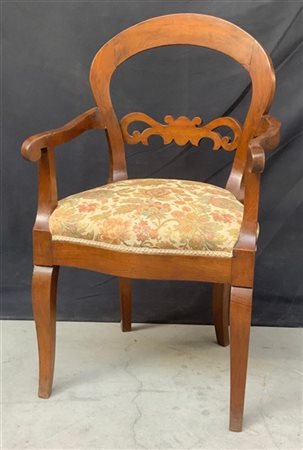 Poltrona di forma mossa in legno, schienale traforato, braccioli terminanti a r