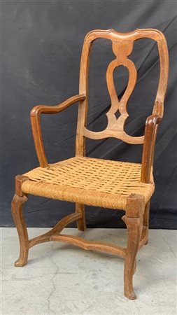 Poltrona di forma mossa in legno intagliato, schienale traforato, seduta impagl