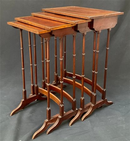 Gruppo di quattro tavolini a nido lastronati in legni vari, piani profilati in