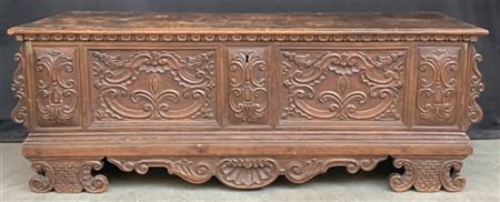 Cassapanca in legno scolpito, fascia sottopiano decorata a unghiature. Cartella