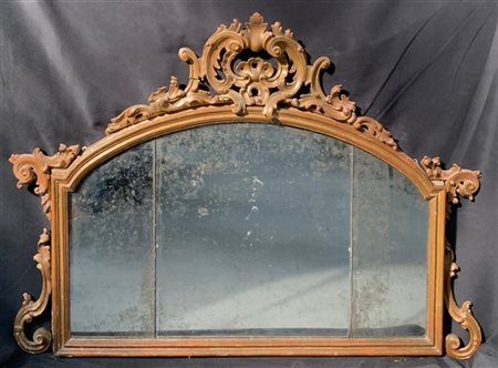 Caminiera in legno intagliato e dorato di forma sagomata decorata con fregi a v