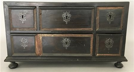 Monetiere in legno ebanizzato con fronte a cinque tiretti e piedi a cipolla. Se