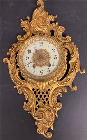 Orologio da parete del tipo "cartel" in metallo dorato. Quadrante bianco a cifr